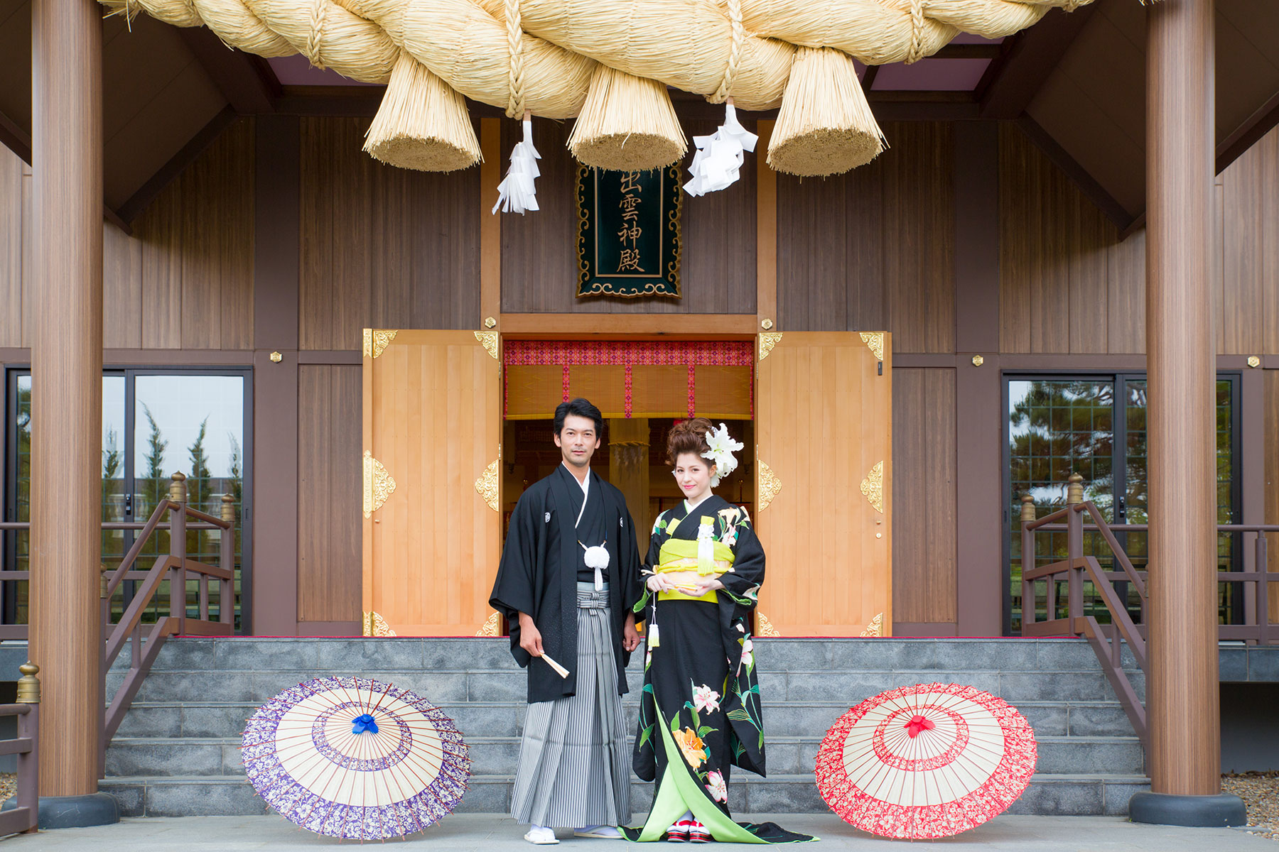 出雲神殿の前に立つ和装の新郎新婦