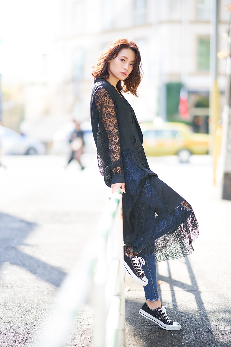 黒いレースの衣装をまとった女性の全身ポートレート